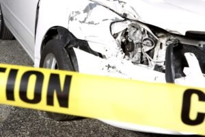 wrecked white car with police tape