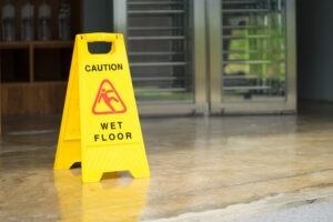 Señalamiento de piso mojado que puede evitar una demanda de responsabilidad de propiedad