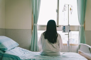 mujer sentada en una cama de hospital