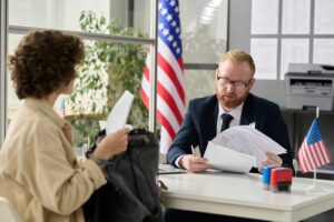 Abogado con cliente en su oficina. Cómo obtener una tarjeta verde sin matrimonio