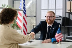 Abogado de inmigración con un cliente en su oficina. ¿Los titulares de tarjetas verdes pueden votar?