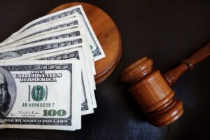 Judges court gavel and assorted money. How to Divide a Wrongful Death Settlement?