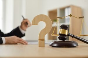 Wooden question mark. Concept of legal services. What does a personal injury lawyer do?
